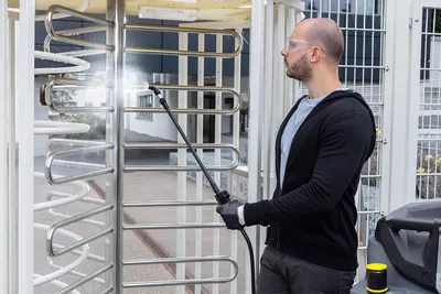Scrubber dryer attachment kit for disinfecting surfaces using a spray. Man seen using scrubber dryer attachment kit for disinfecting surfaces using a spray.