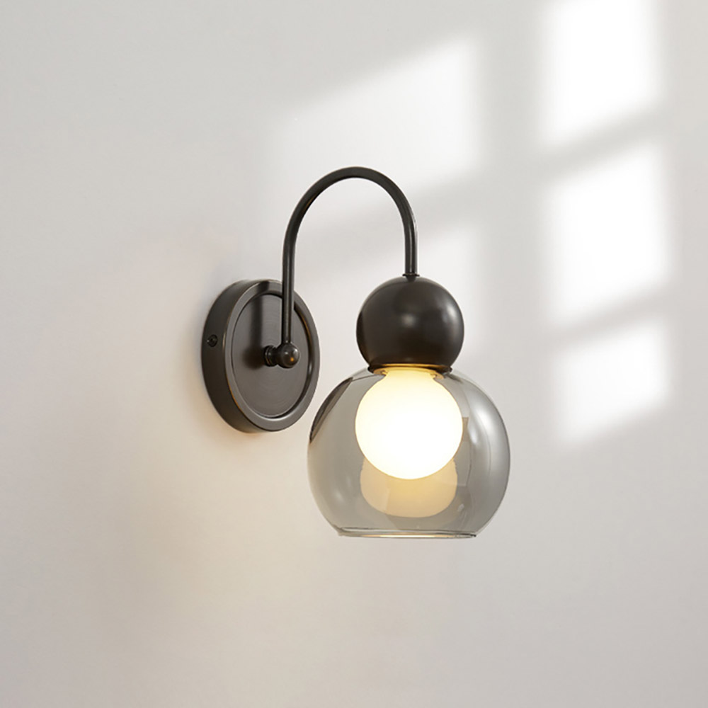 工業風圓球玻璃壁燈特寫，白色牆面搭配自然採光陰影，展現極簡燈飾質感。