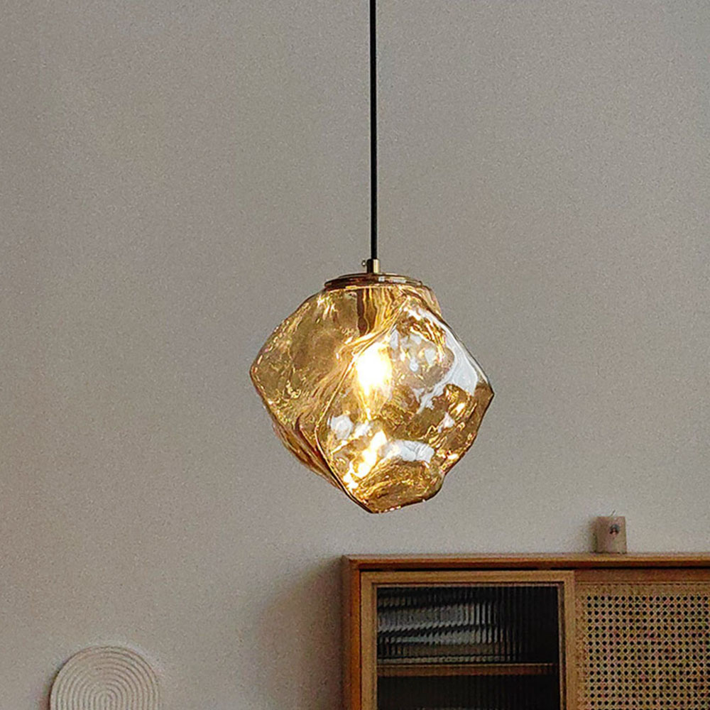 簡約室內空間中的琥珀色不規則玻璃吊燈，搭配木質邊櫃營造北歐風居家氛圍