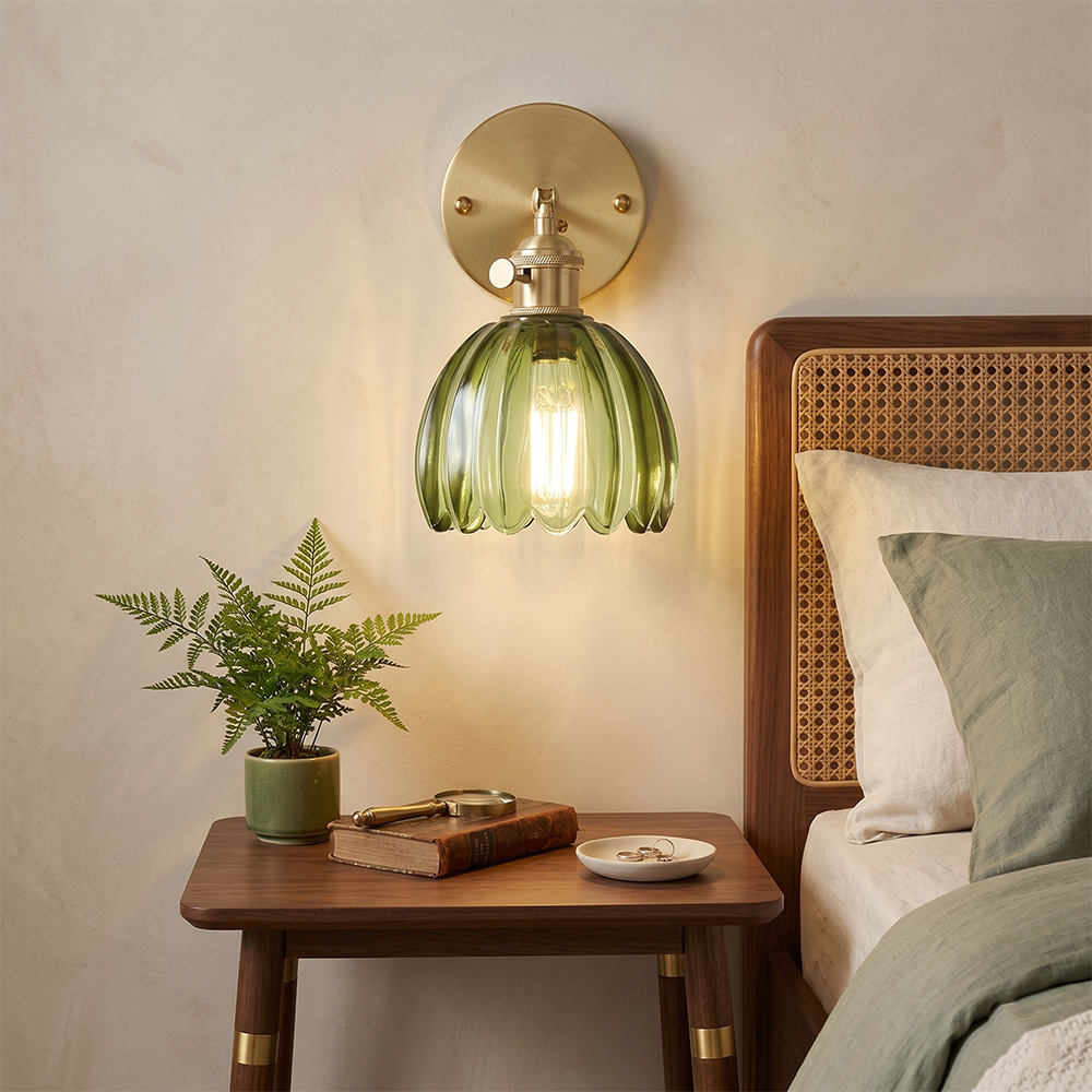法式復古綠色玻璃壁燈安裝在臥室床頭的實景圖，搭配原木床頭櫃與綠意盆栽。