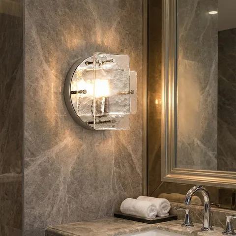 安裝於大理石牆面的輕奢風格玻璃壁燈，作為浴室鏡前燈使用，呈現溫暖光影