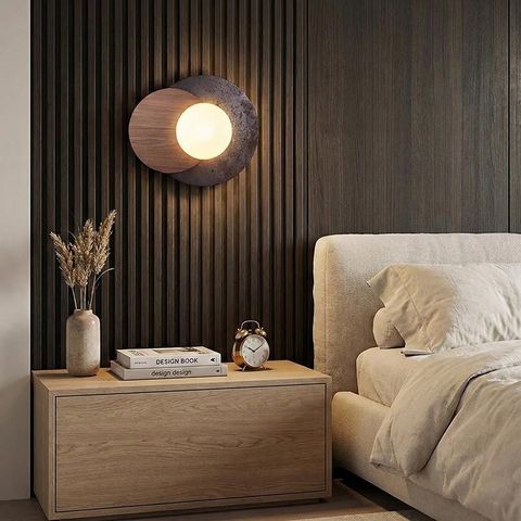 現代北歐風木質圓形壁燈安裝於臥室床頭櫃上方，暖色光營造舒適睡眠氛圍