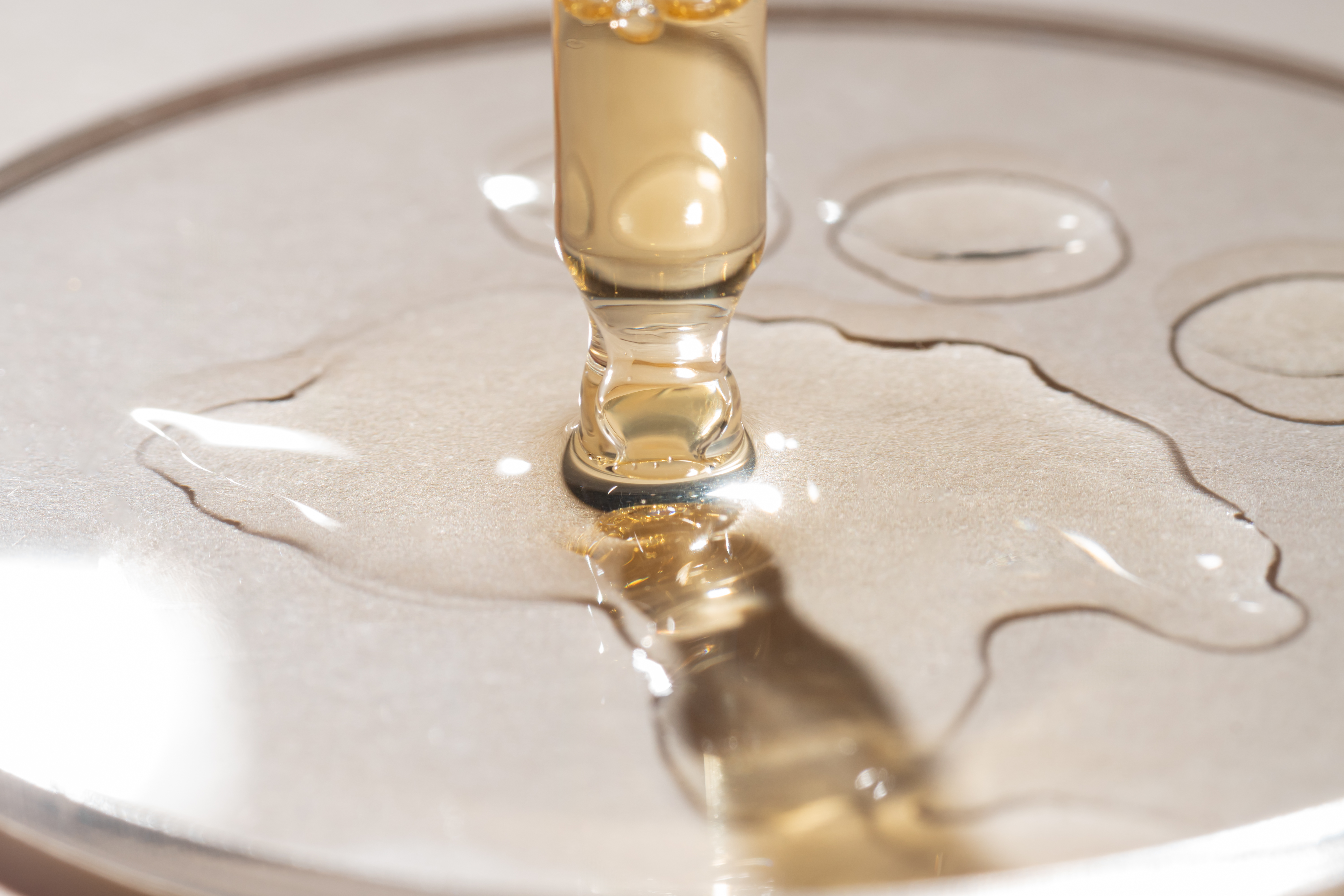 bottle-pipette-dropper-close-up-liquid-yelloworange-retinol-vitamin-c-gel-serum-beige-background