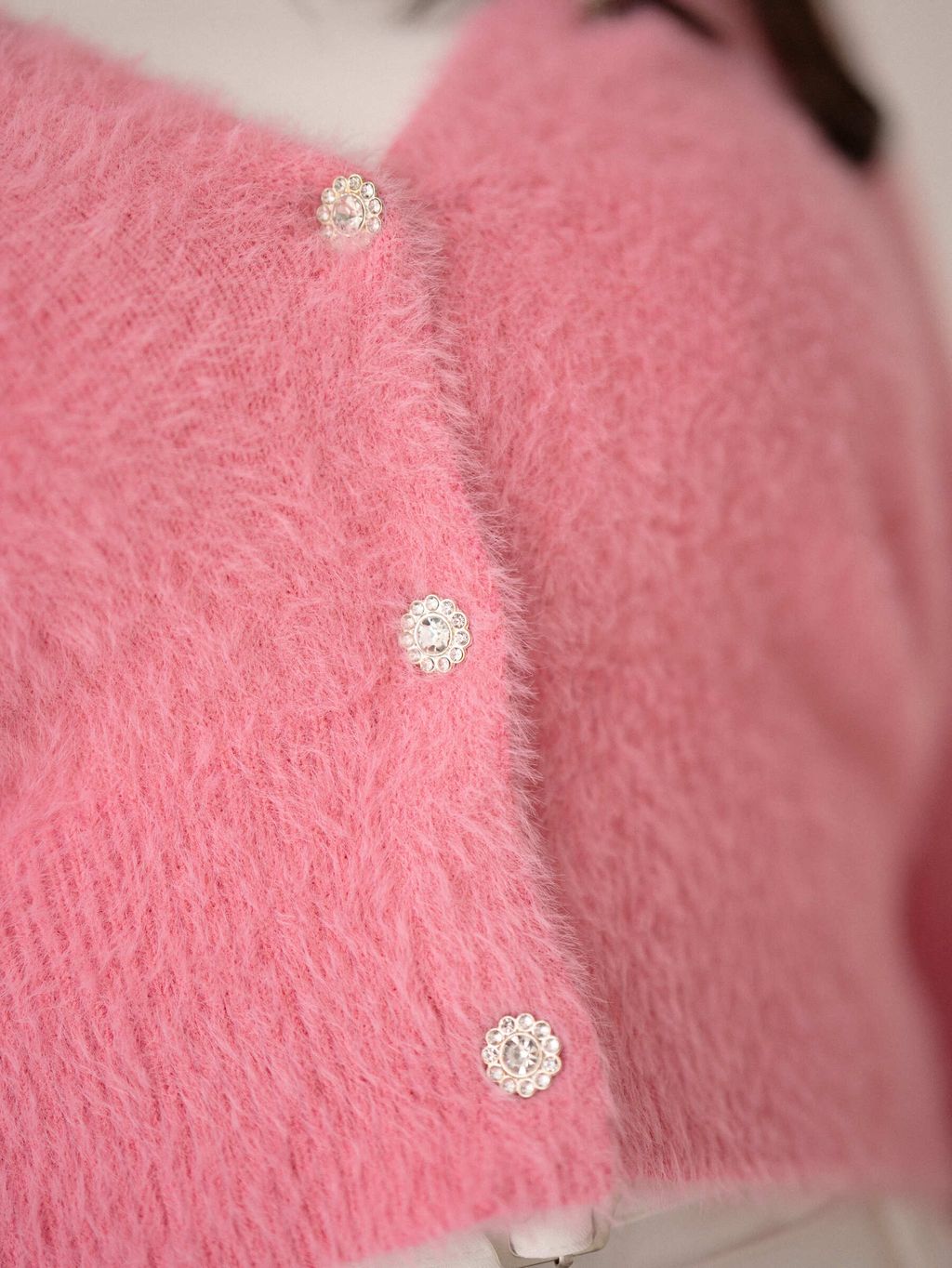 Close-up of petal-shaped trim on knit cardigan sleeve for feminine detail