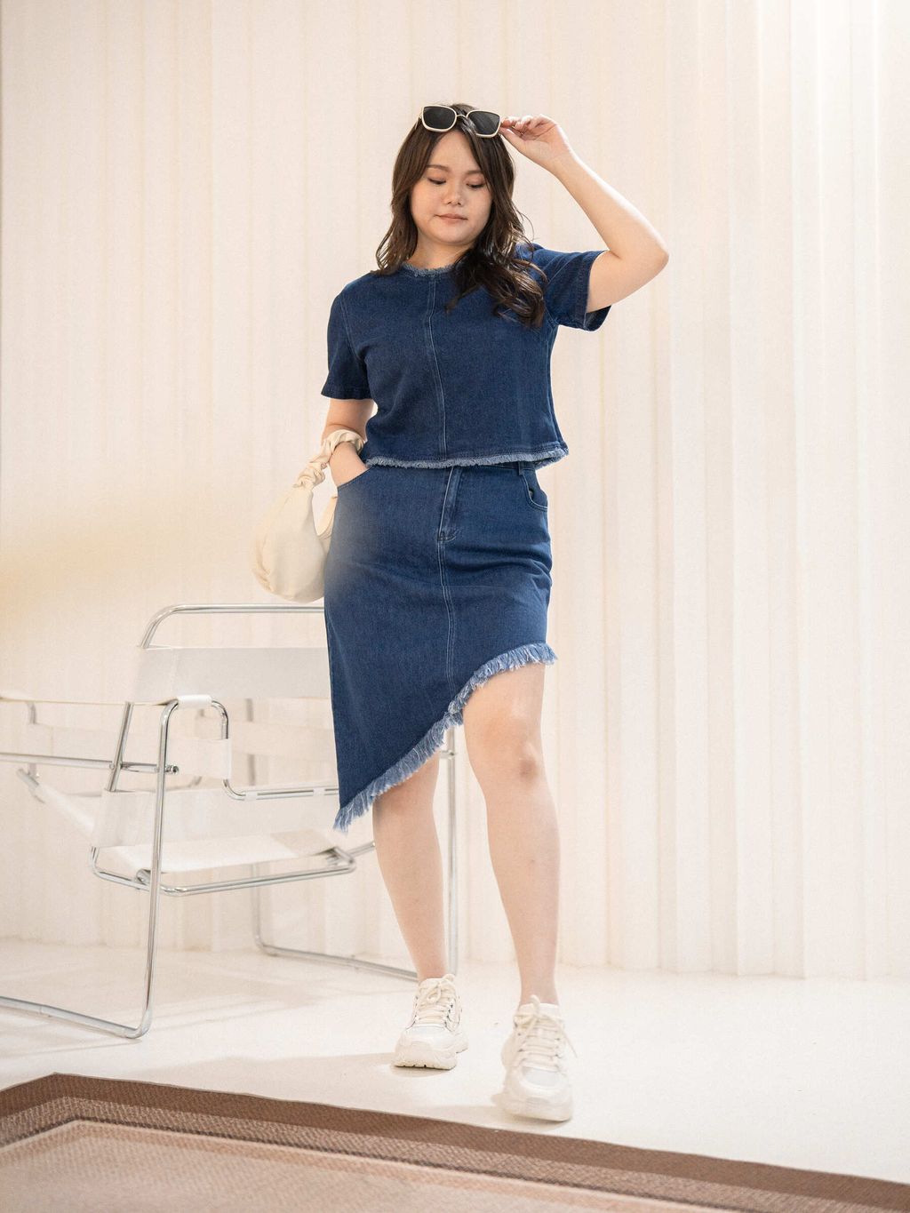 Plus-size outfit featuring a frayed denim top paired with a matching denim skirt