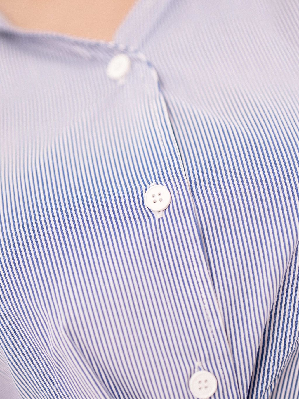 White buttons on a classic vertical stripe blouse.