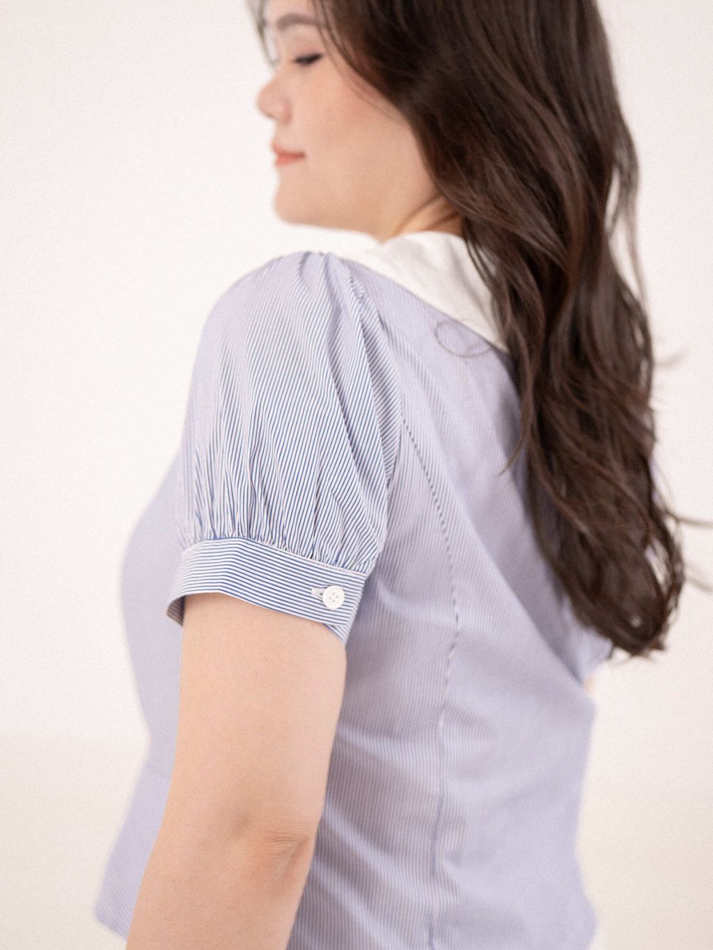 Back view of striped cotton blouse with gentle puff sleeves.