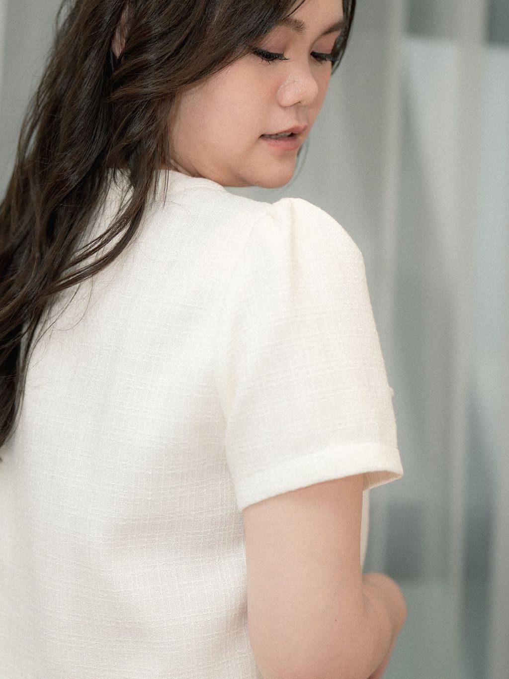 Side profile showing puff sleeve and structured cut of classic tweed cropped blouse