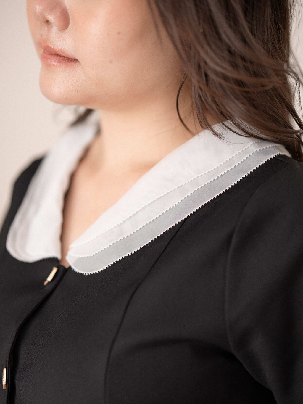 Close-up of layered white scholar collar on a black blouse, showing the crisp contrast and clean stitching.