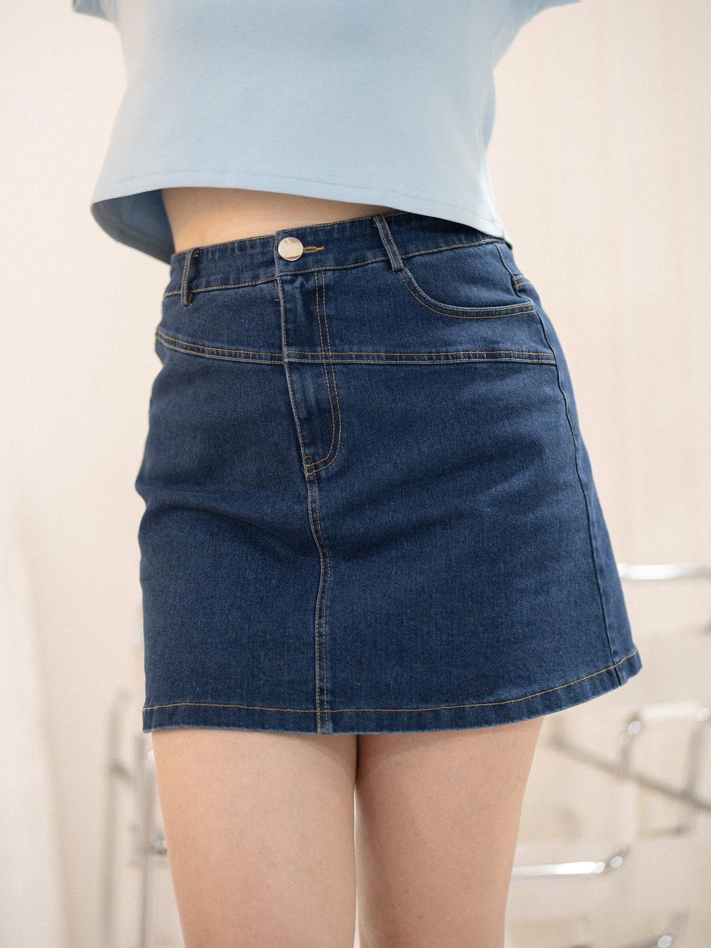 Close-up of dark blue denim mini skirt front design