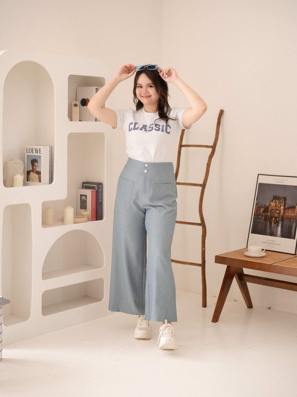 Model posing indoors in wide-leg pants and a fitted top, showcasing flattering waist fit.
