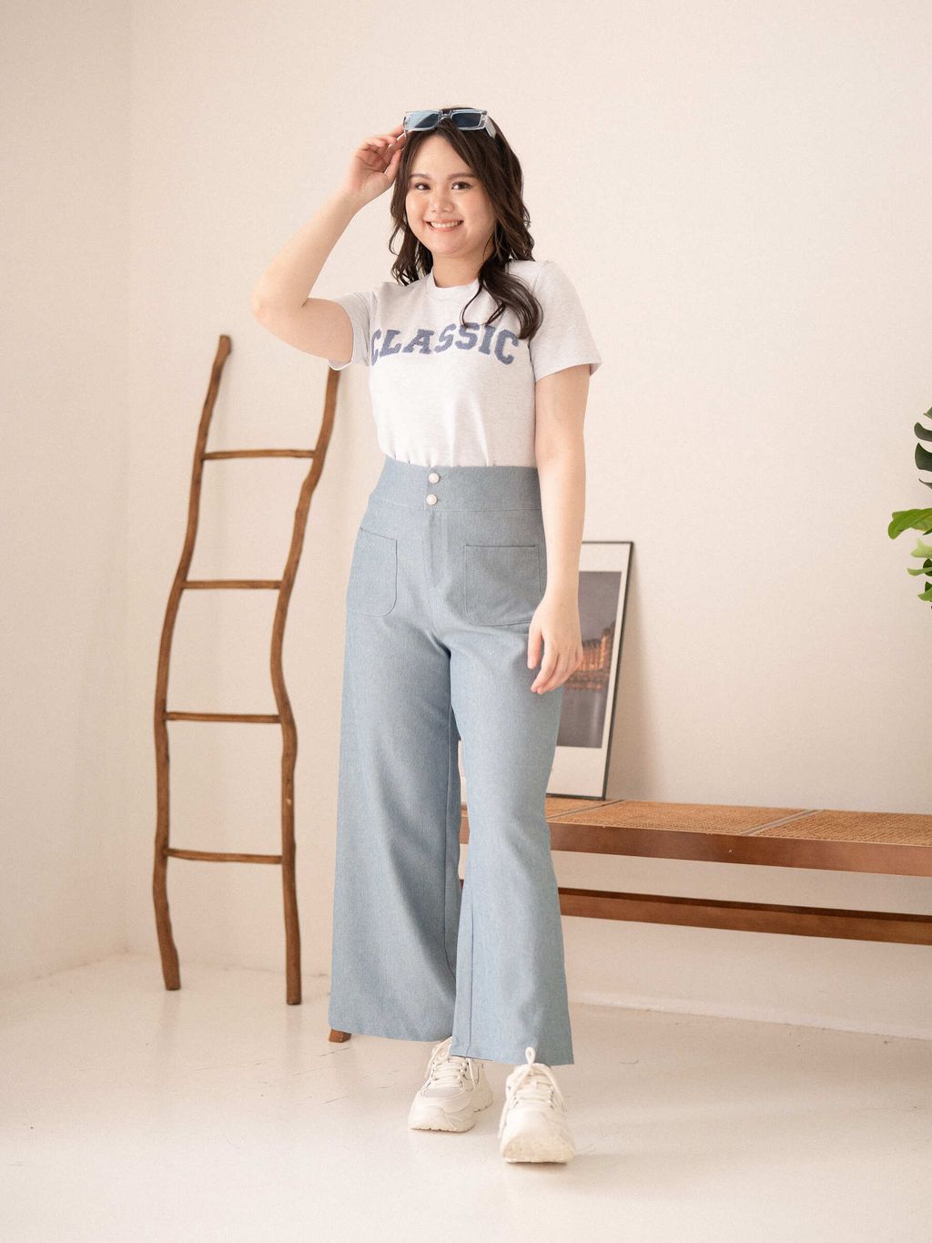 Plus-size model in light blue wide-leg Urban Grace Pants, styled with a white cropped blouse.