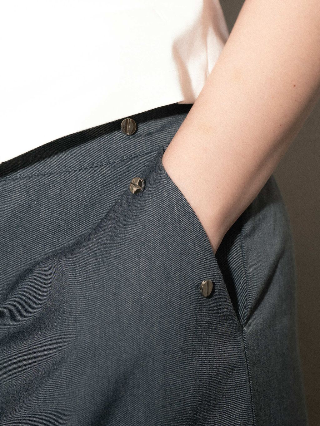 Elegant wide-leg trousers with decorative metal studs on pocket edges.