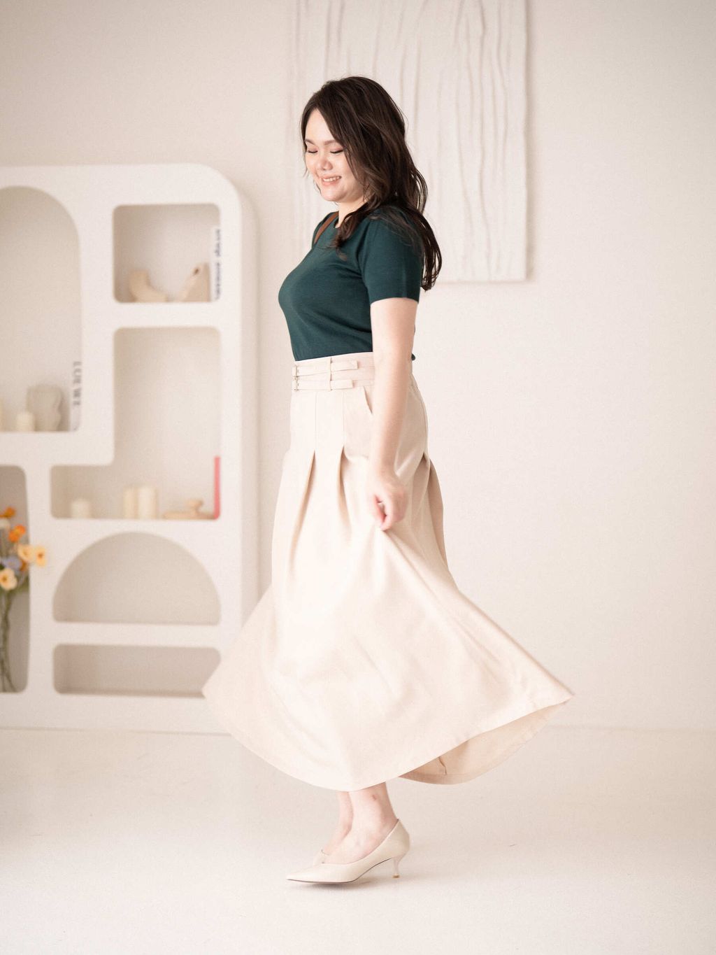 Side view of A-line pleated skirt showing flattering flare and structure.