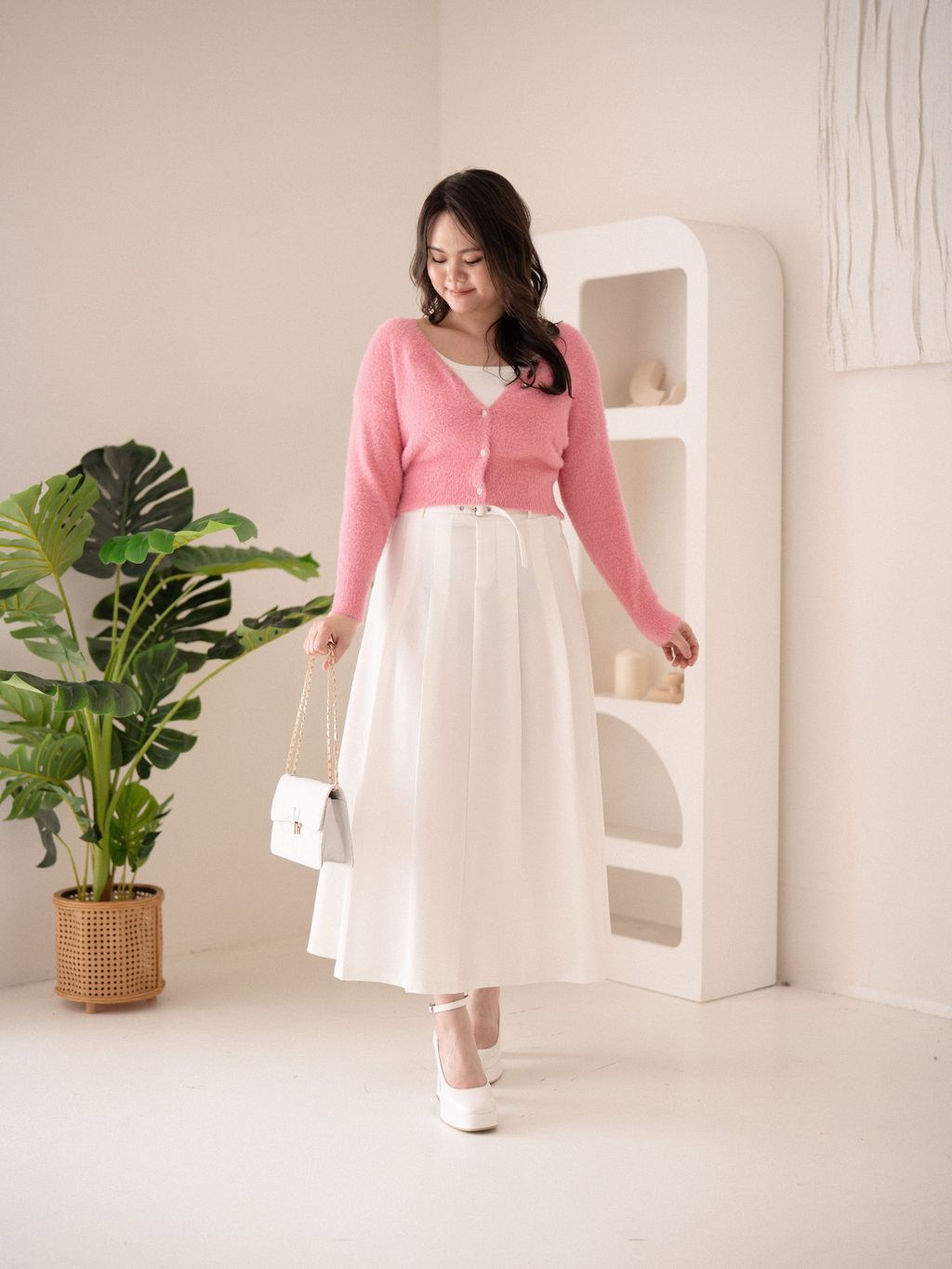 Soft pink sweater with white skirt from behind – cozy and feminine styling.