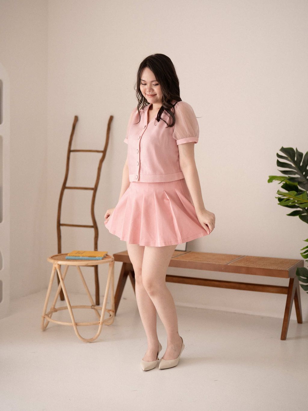 Pink flare mini skirt styled with ivory heels and handbag for feminine look