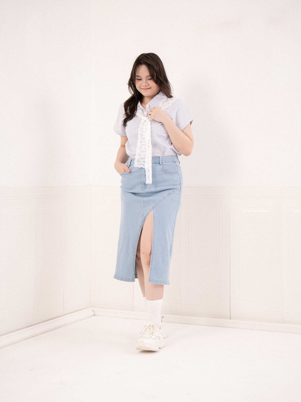 Casual outfit pairing a striped collared shirt and front-slit denim skirt.