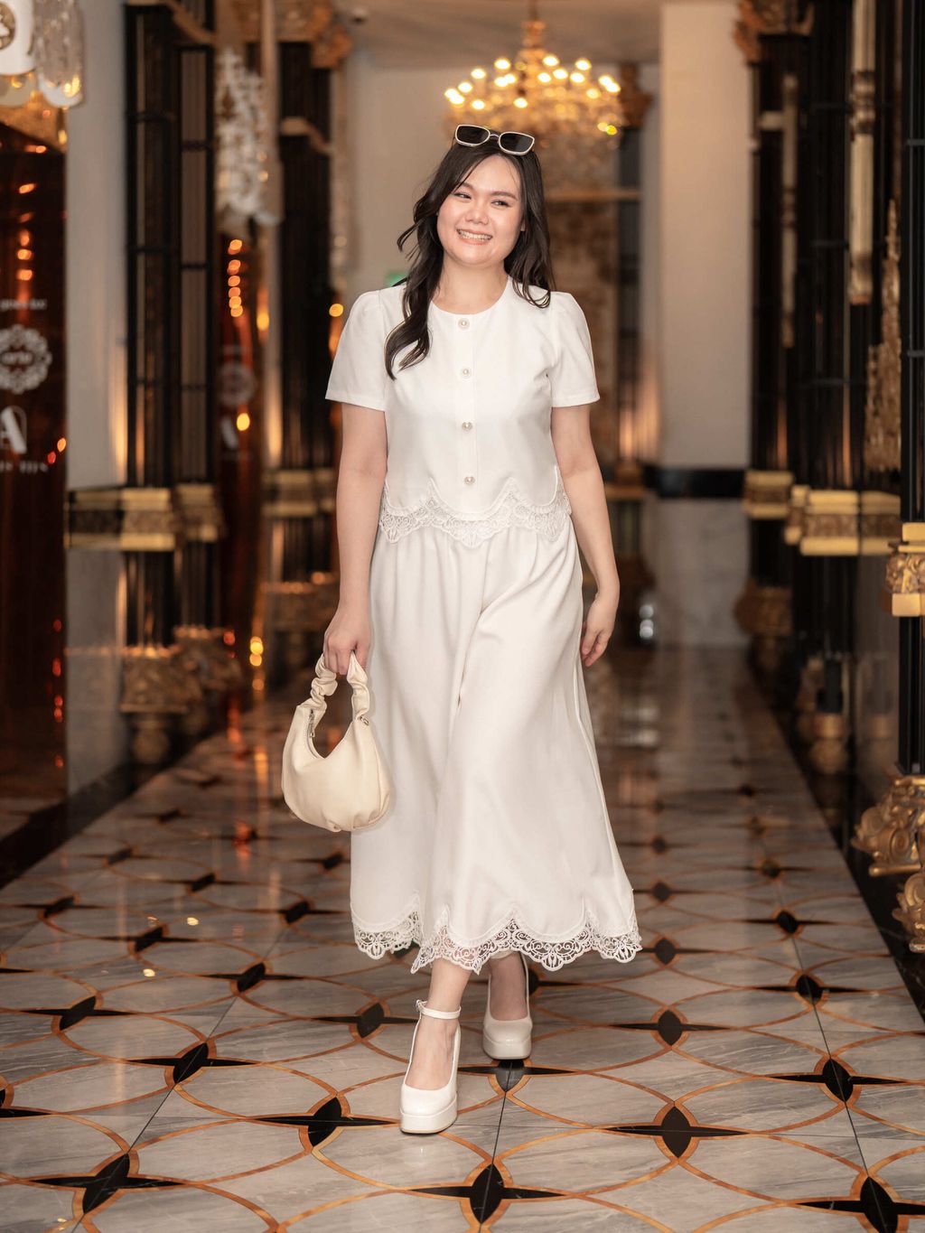Confident smile and flowing movement as the model showcases the white version of the lace outfit.