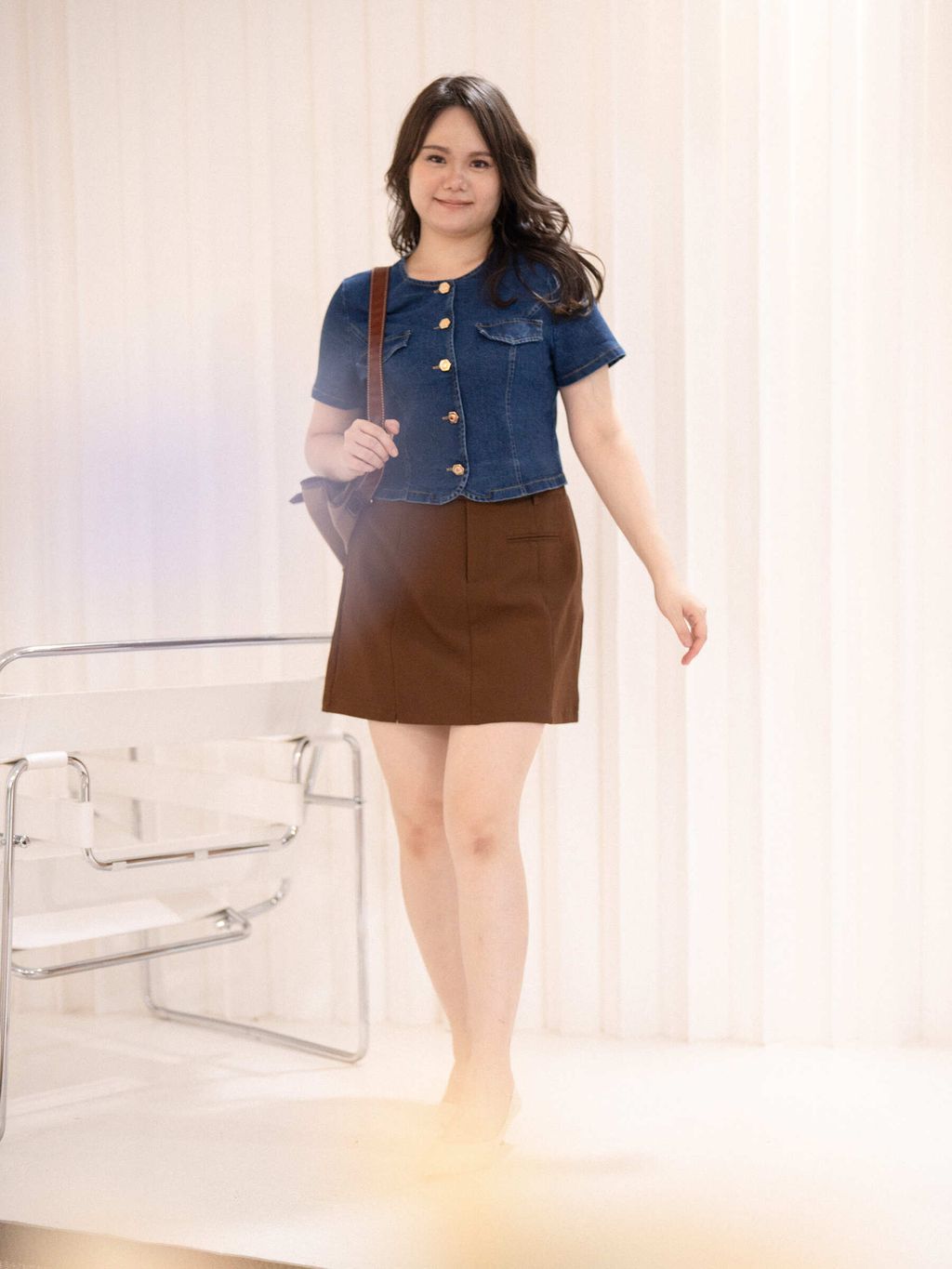 Plus-size model in cropped denim top with golden buttons