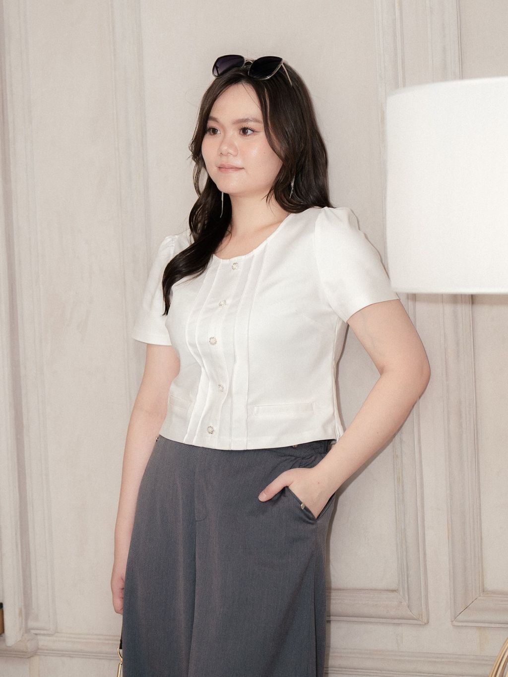 Curvy woman in structured short sleeve blouse with pleats