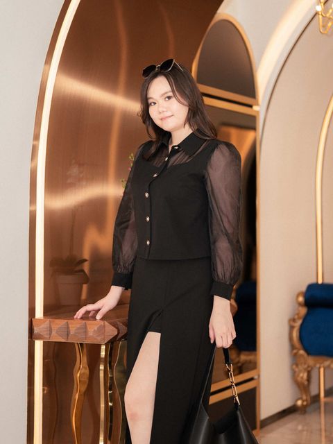 Elegant plus-size outfit featuring sheer sleeve blouse and slit skirt.