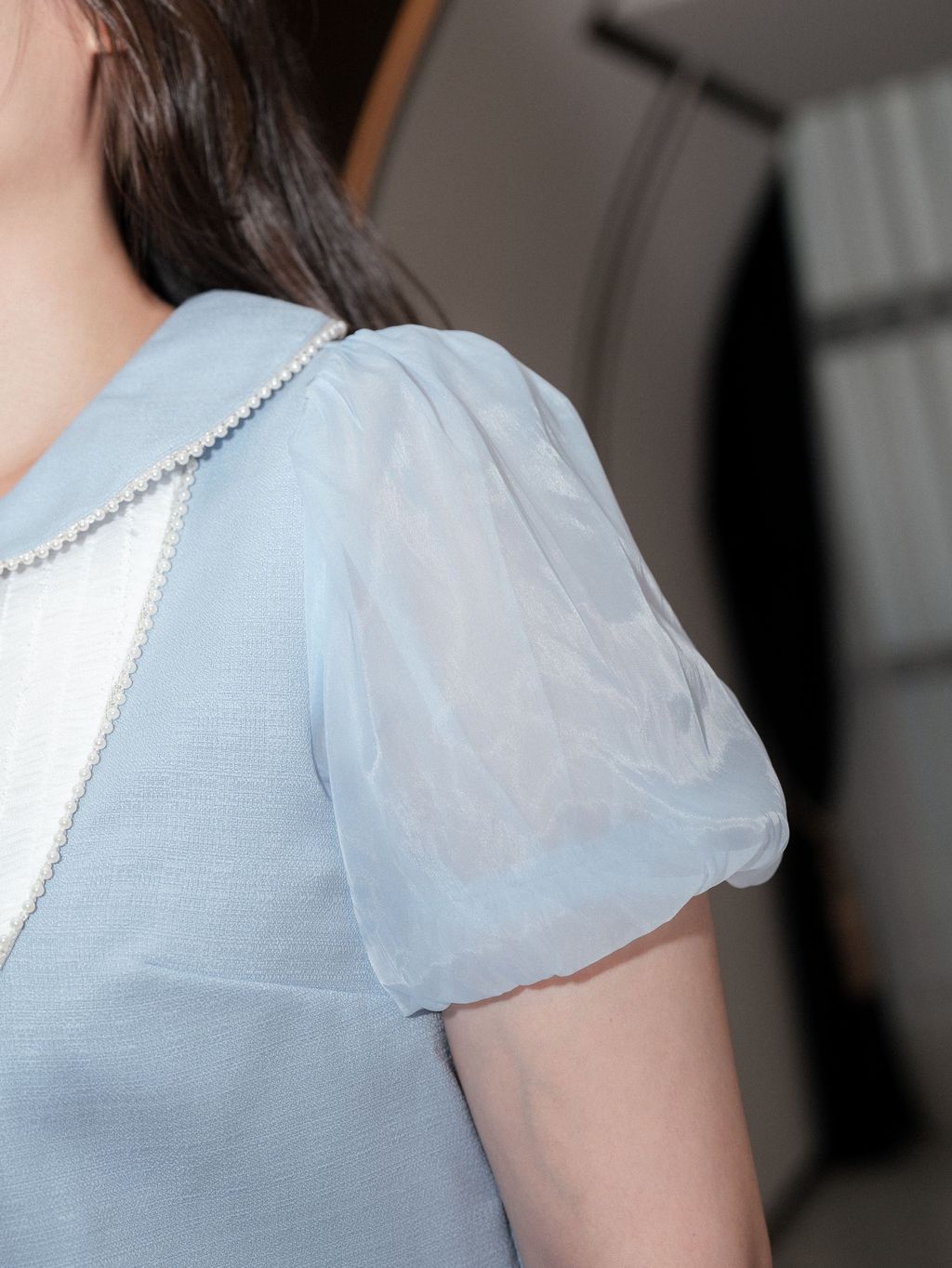 Close-up of sheer puff sleeve showing soft fabric texture and shoulder seam.
