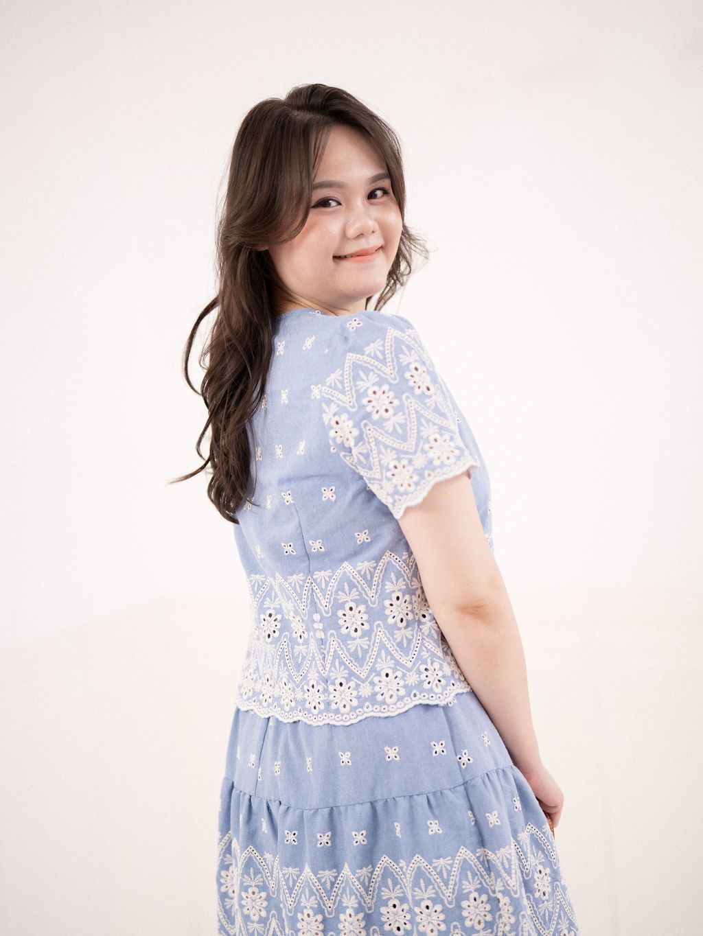 Back view of scalloped hem eyelet blouse in soft blue.
