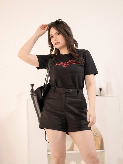 Close-up of black Dream Voyage graphic T-shirt with “Time Flies, Dream Voyage Me” slogan in red, styled on a curvy figure for a confident streetwear feel.