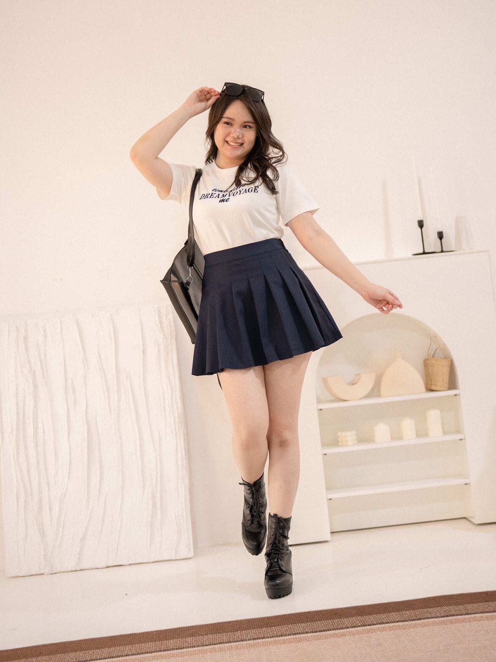 White Dream Voyage Tee styled with a navy pleated mini skirt, ideal for a youthful, chic look.