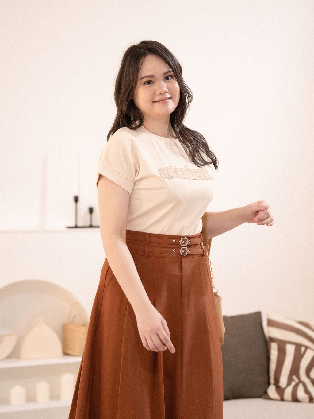 Close-up of light beige tee’s stitched chest patch, showcasing its unique fabric texture.