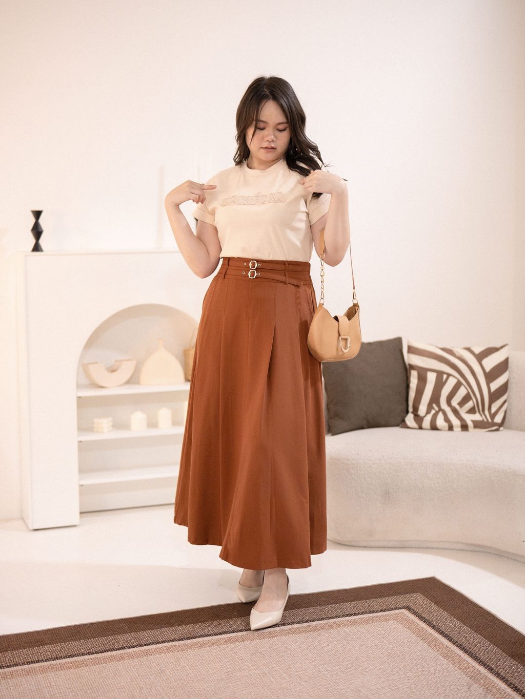 Model in light beige Signature Patch Tee and high-waisted bottom, highlighting effortless plus-size chic.