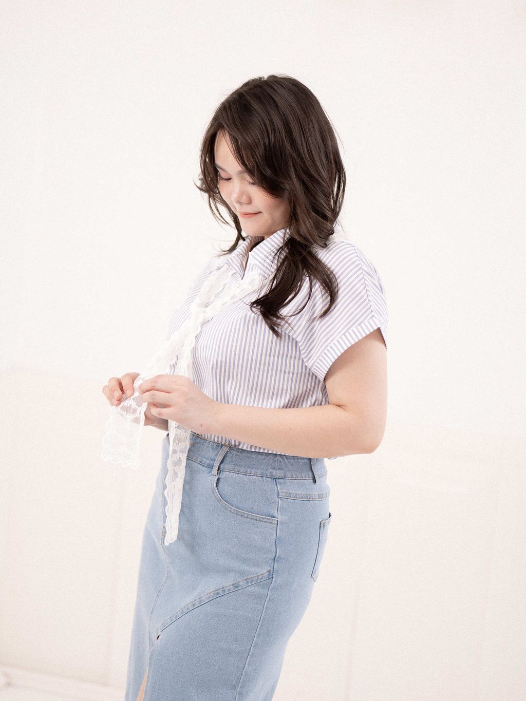 Delicate white embroidered lace fabric held in hand for texture close-up.