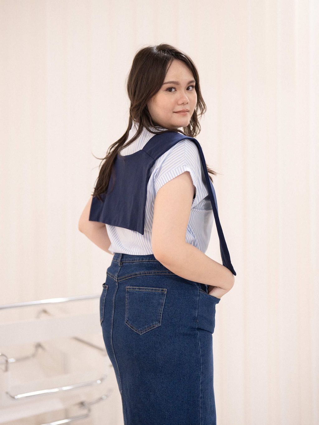 Back view of striped shirt with navy pullover over shoulders