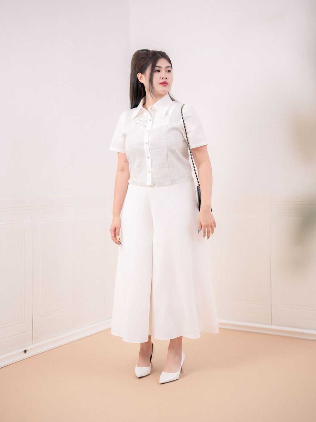 Feminine plus-size blouse styled with white culottes.