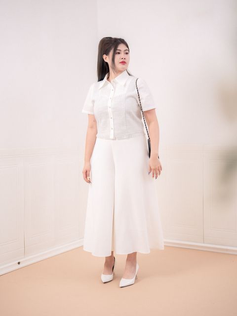 Feminine plus-size blouse styled with white culottes.