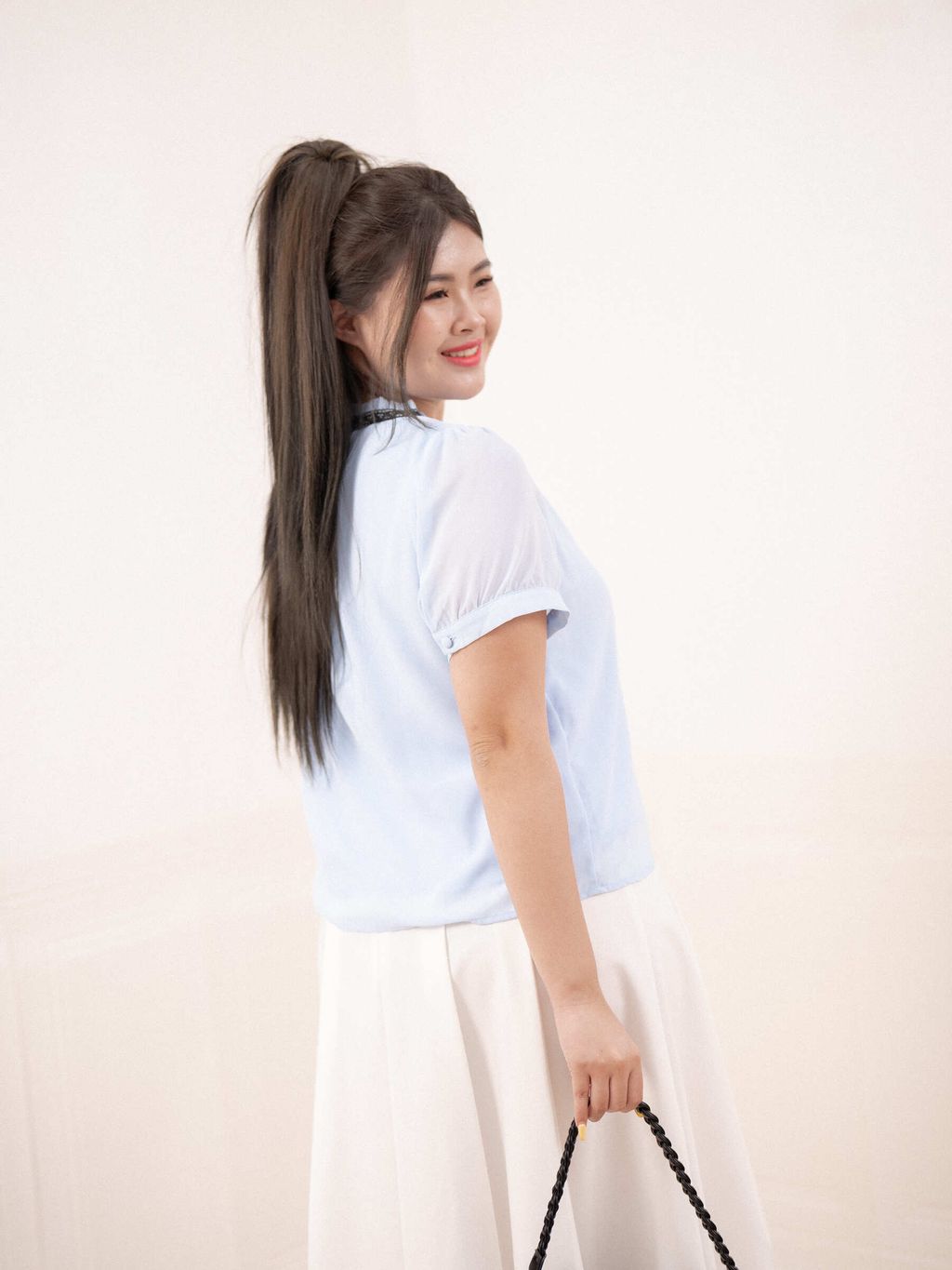 Back view of light blue ribbon-tie blouse with sheer sleeves