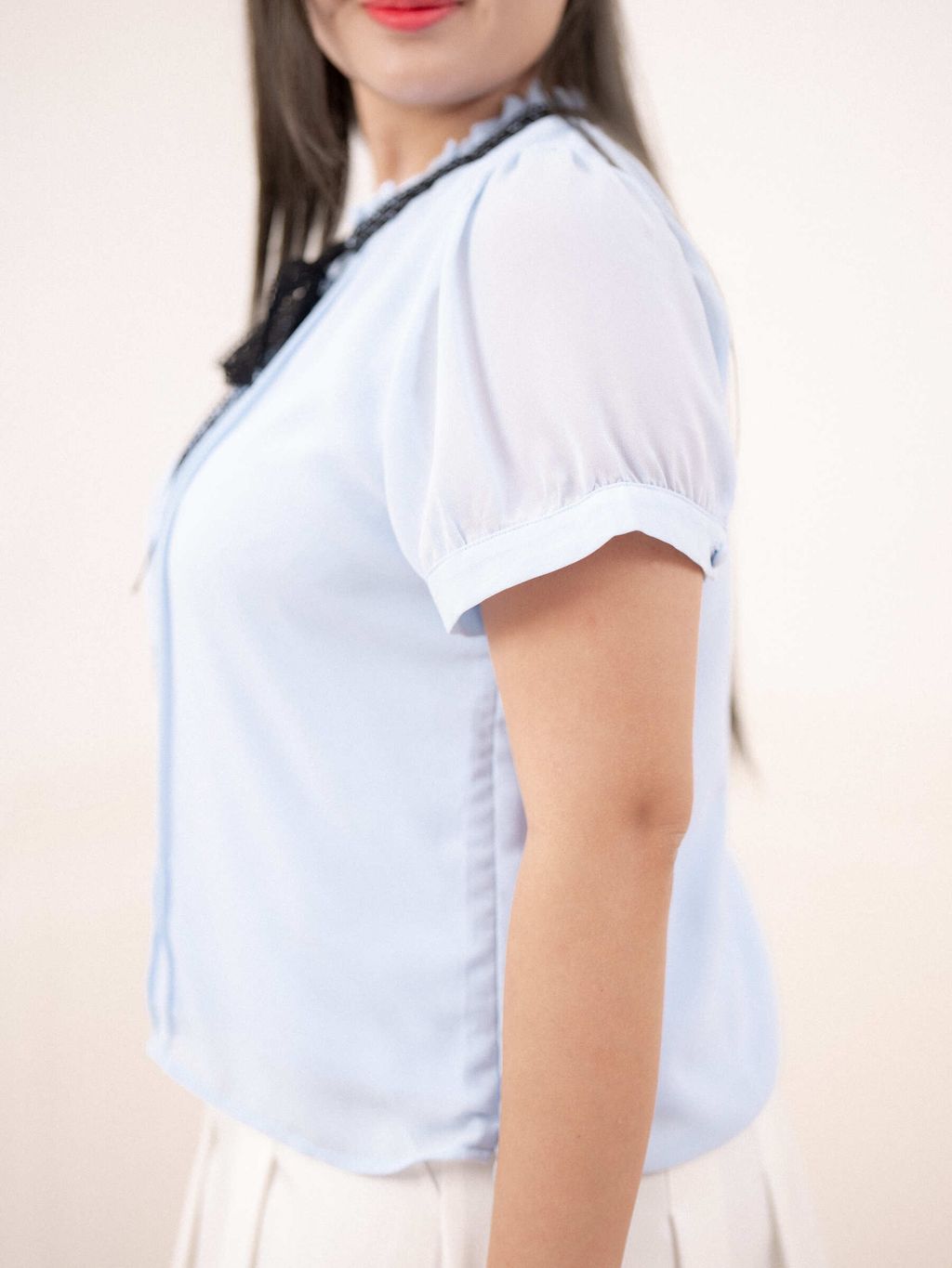 Side view showing puff sleeve and sheer fabric of the blouse