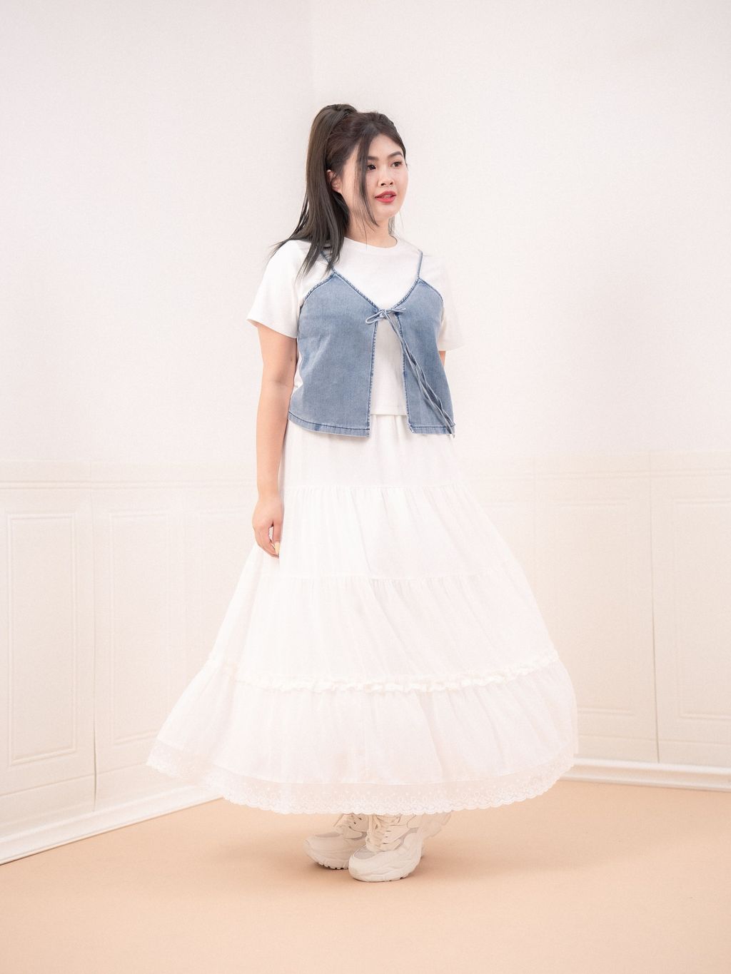 Playful layering style with white tee and denim outer vest