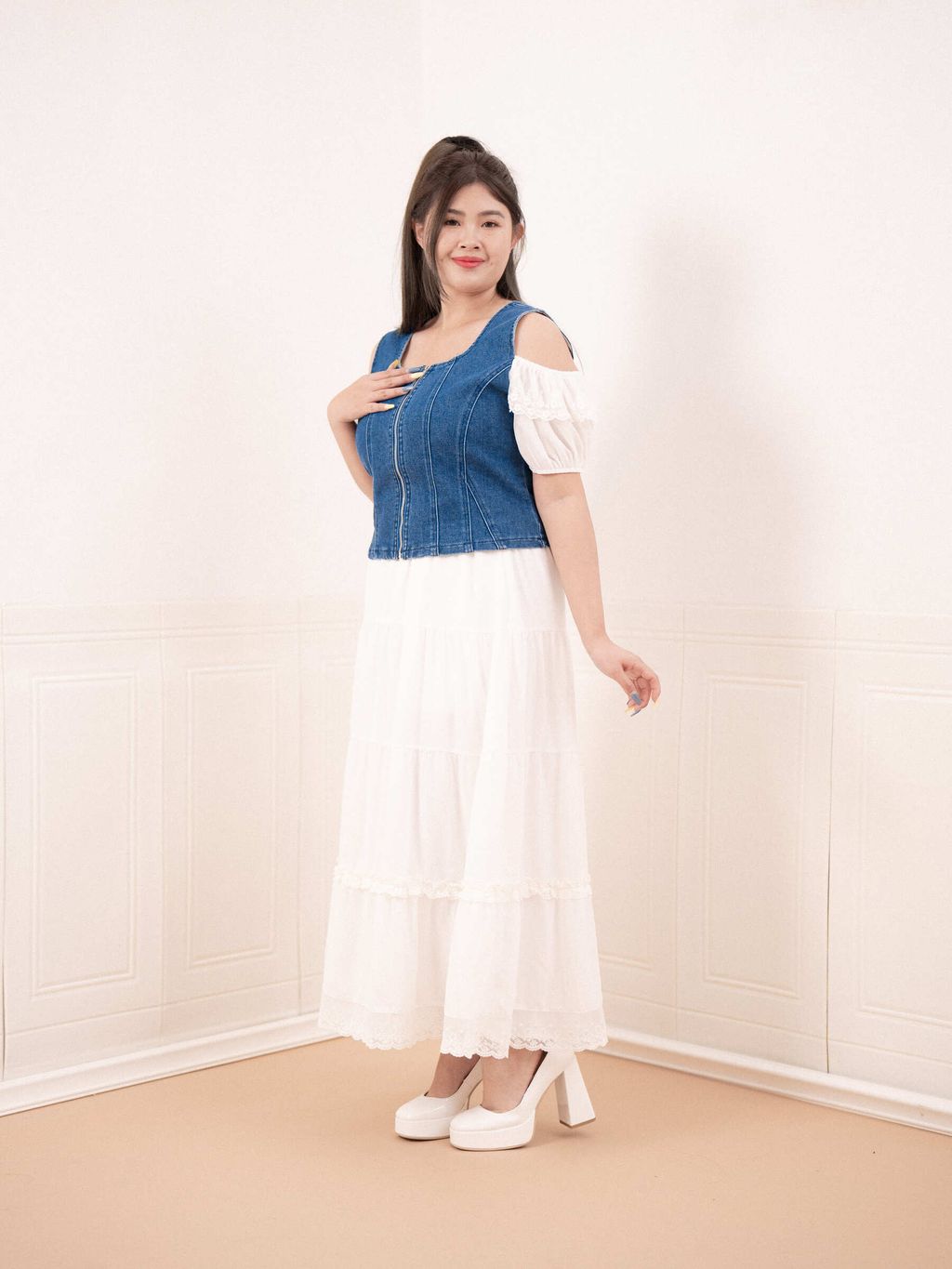 Plus-size woman wearing square neckline denim zip-up top with white dress