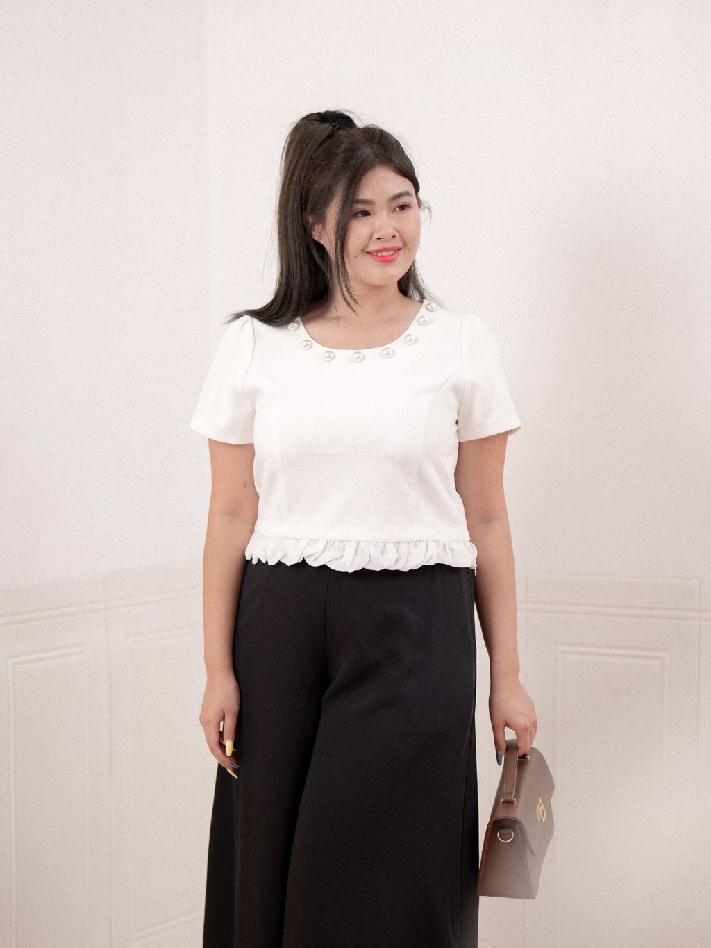 White pearl neckline top styled with black wide-leg pants