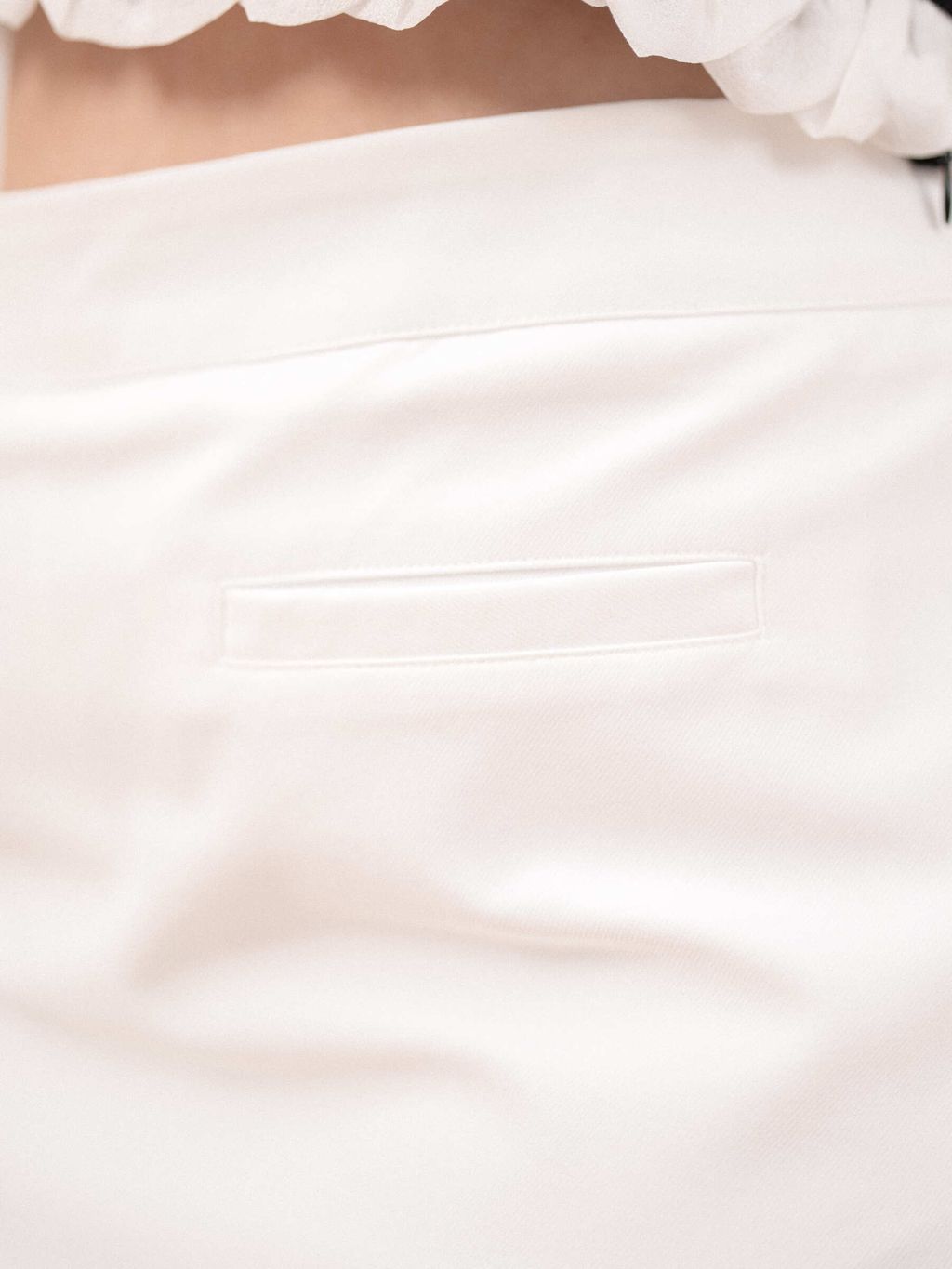 Close-up of ruffle trim and clean skirt tailoring