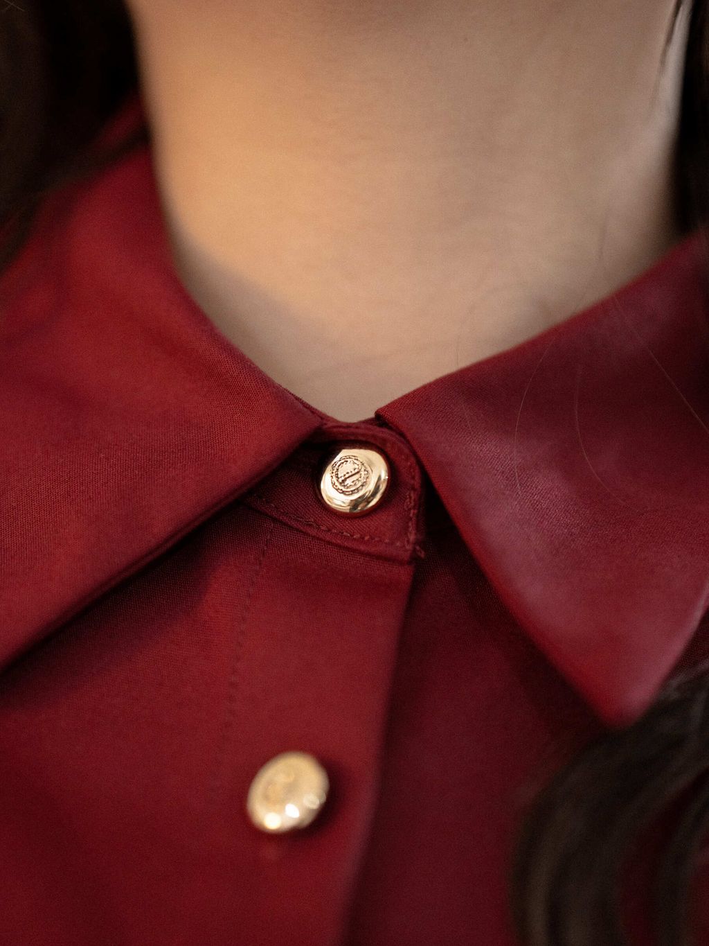 Close-up of gold button and collar design on crimson red plus-size dress
