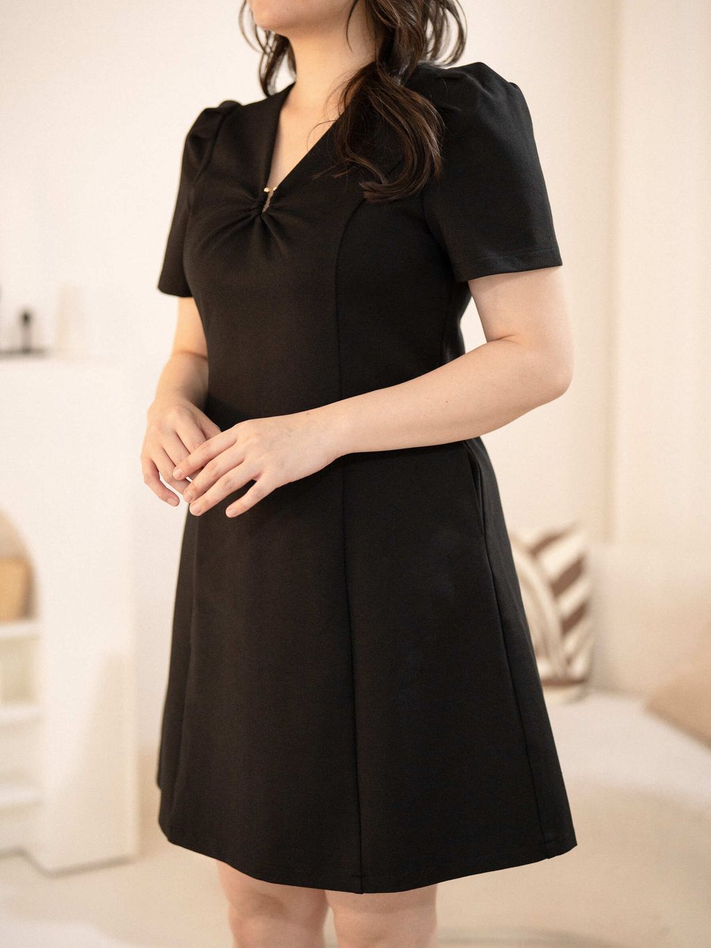 Front angled shot showing structure and neckline detail of black dress