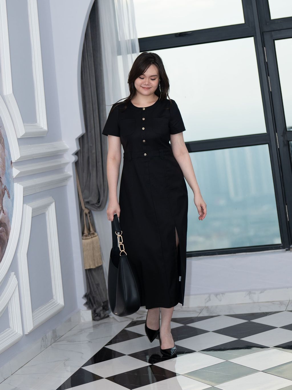 Full-body shot of plus-size woman walking confidently in black slit pocket dress.