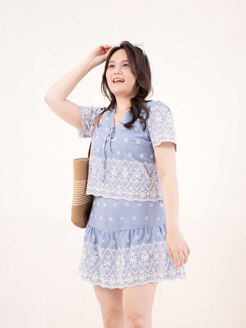 Plus-size woman wearing a light blue eyelet mini skirt with scalloped hem