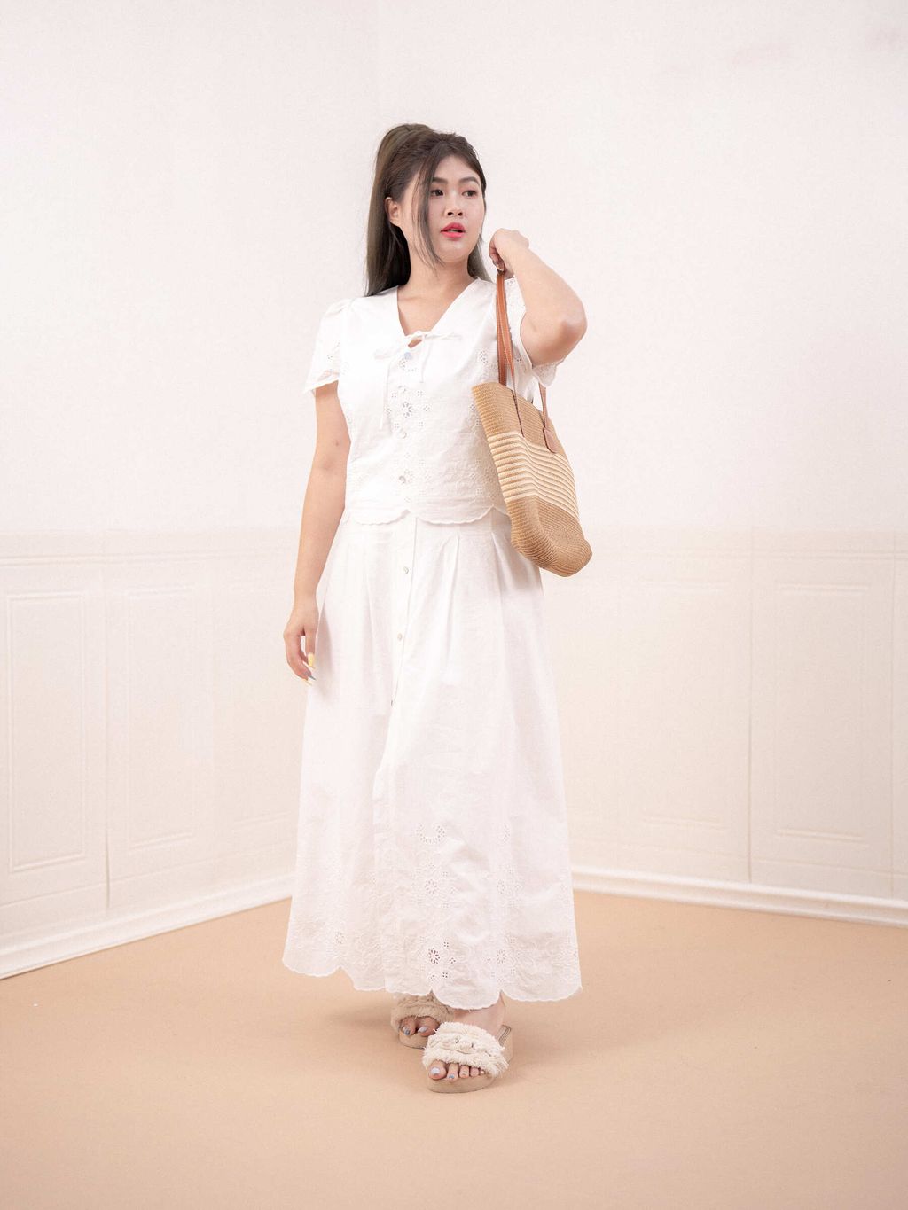 Plus-size woman wearing a white eyelet maxi skirt with floral embroidery