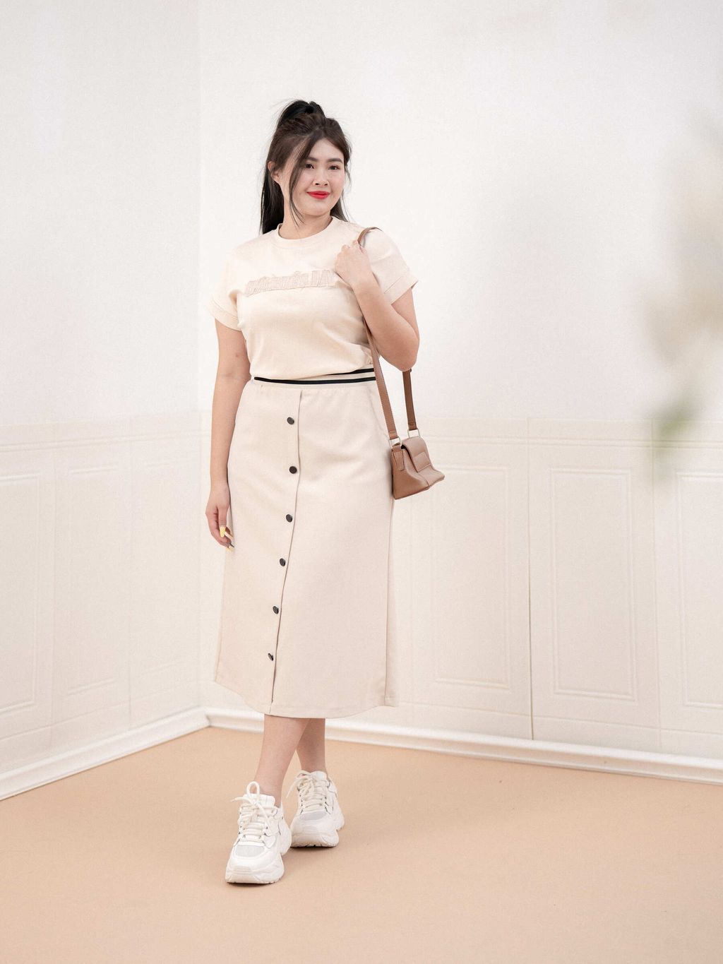 Model in beige version of midi skirt with contrast waistband