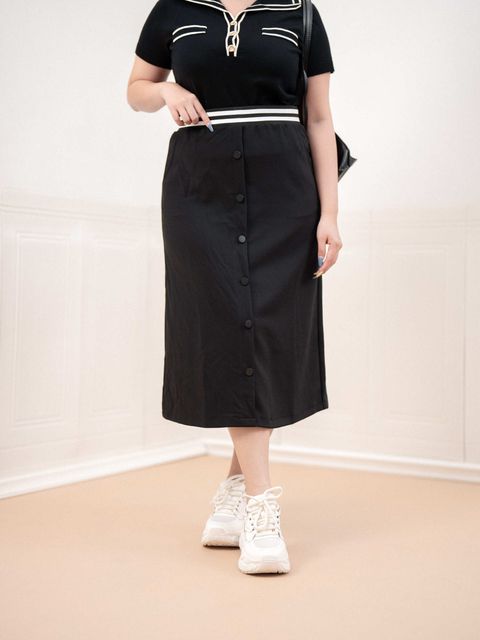 Front view of black A-line midi skirt styled with sneakers