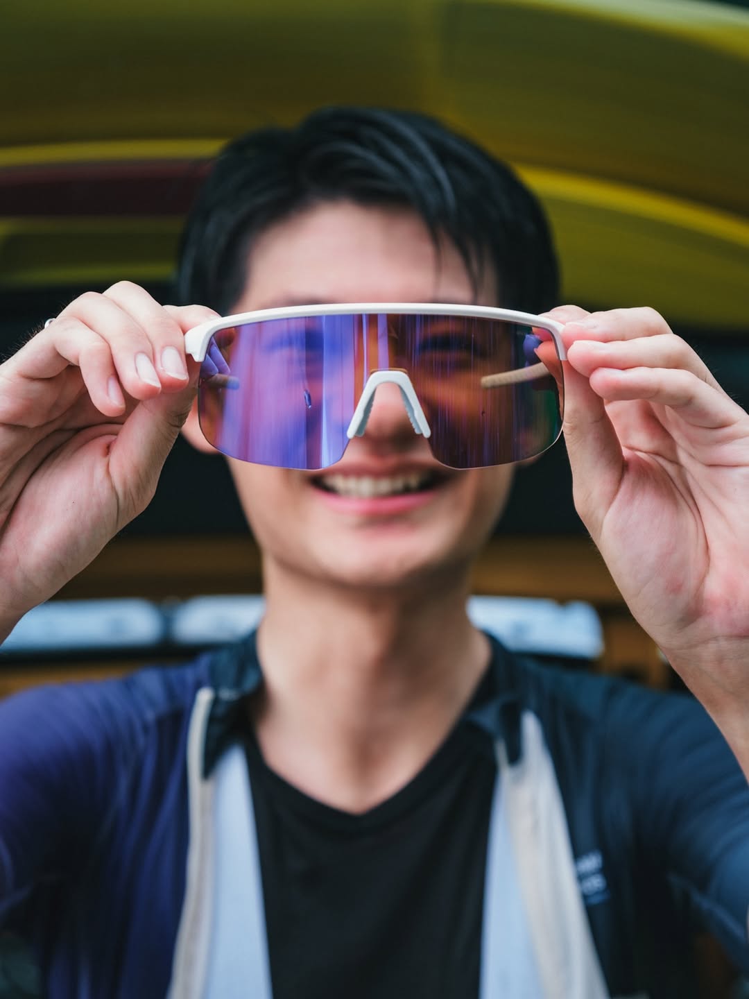 手持 Altalist 眼鏡特寫，背景為藍天