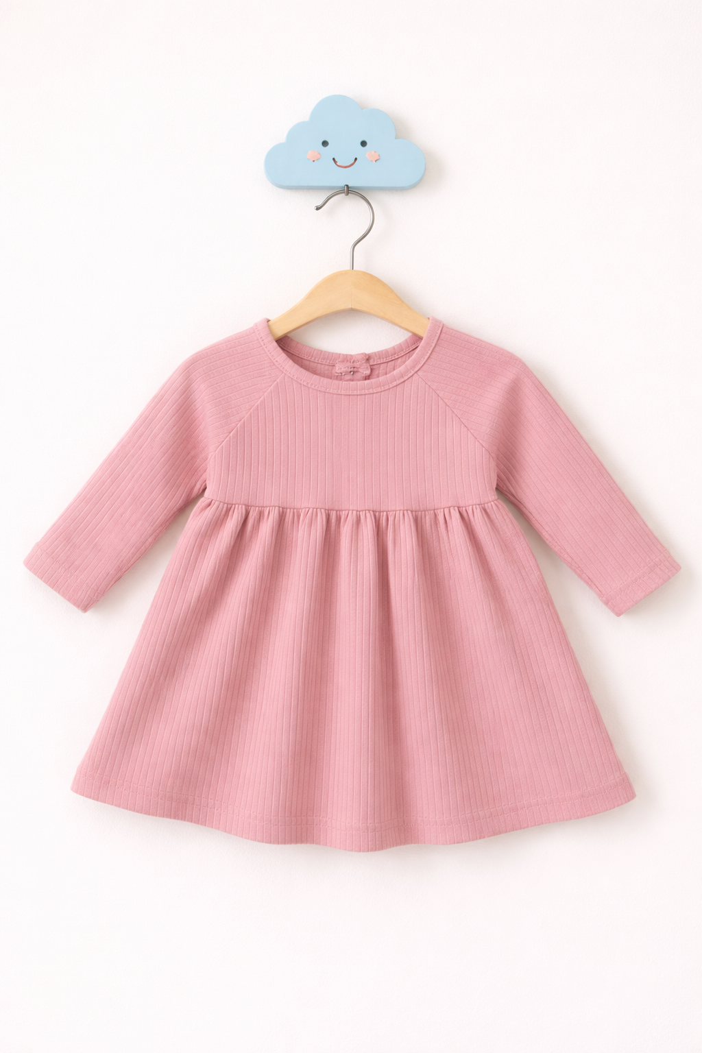 Soft pink baby dress on hanger